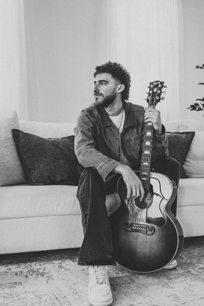 Chandler Letner seated with guitar, color