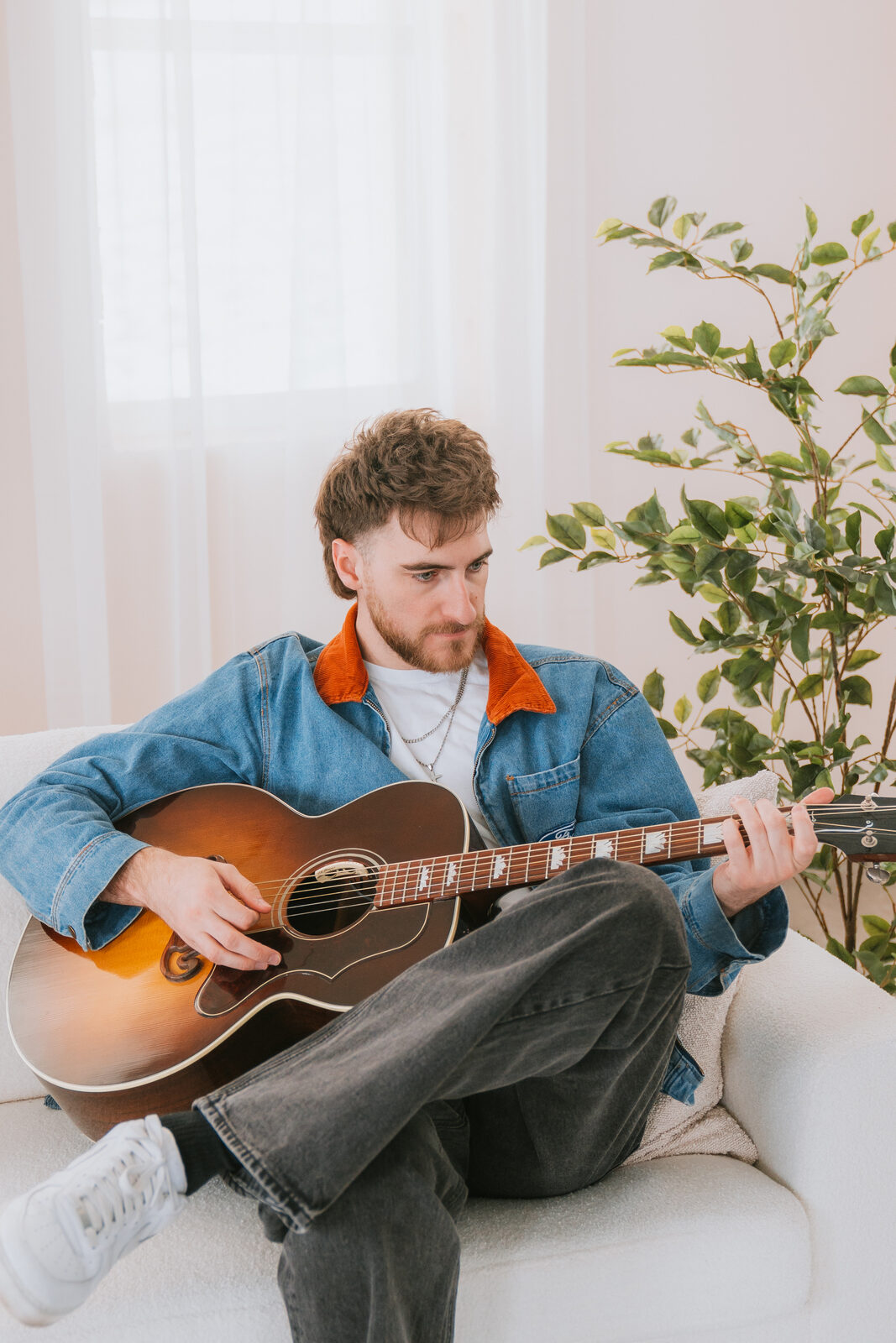 Chandler Letner playing acoustic guitar, color portrait