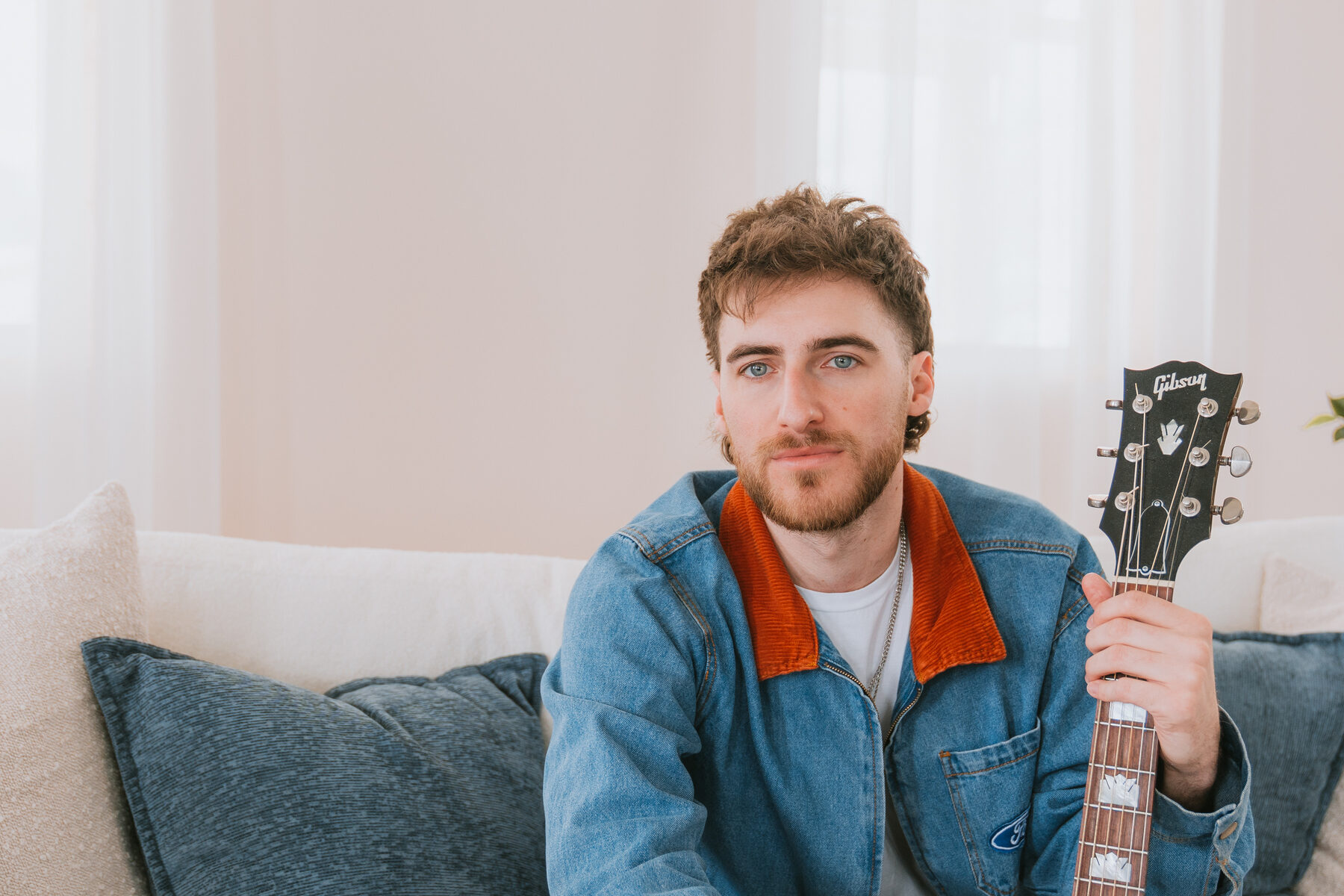 Chandler Letner holding acoustic guitar close to camera