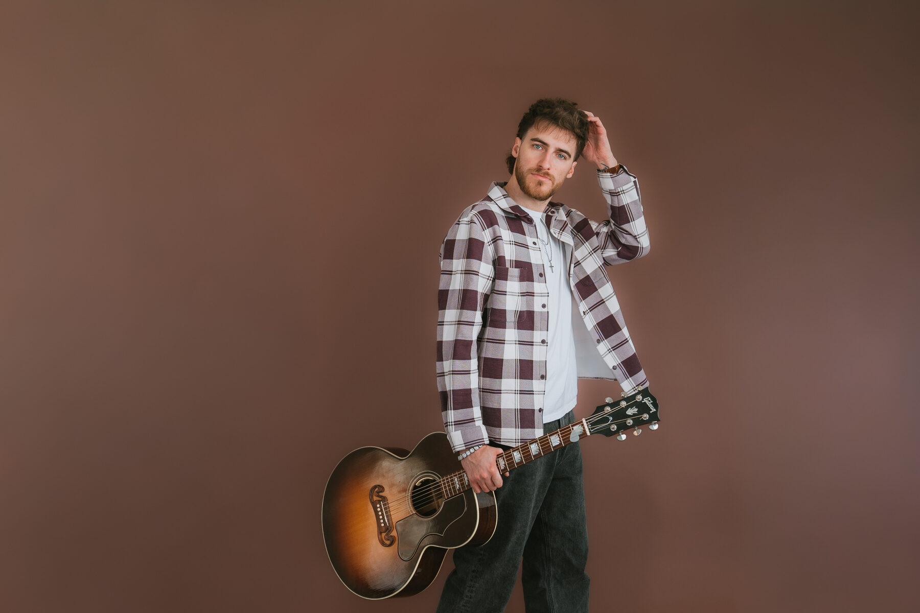 Chandler Letner with acoustic guitar, color studio portrait