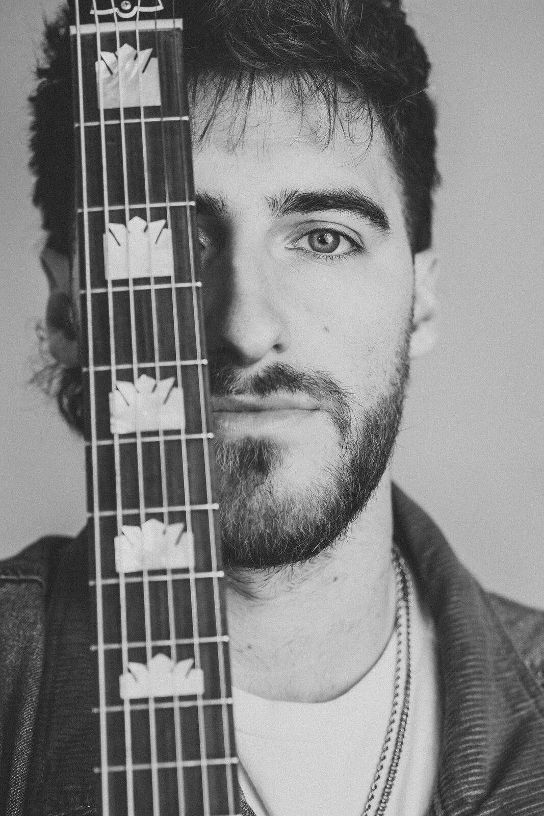Chandler Letner, black and white portrait with guitar fretboard